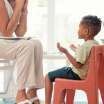 Caregiver calmly supporting a child with autism through communication and reassurance